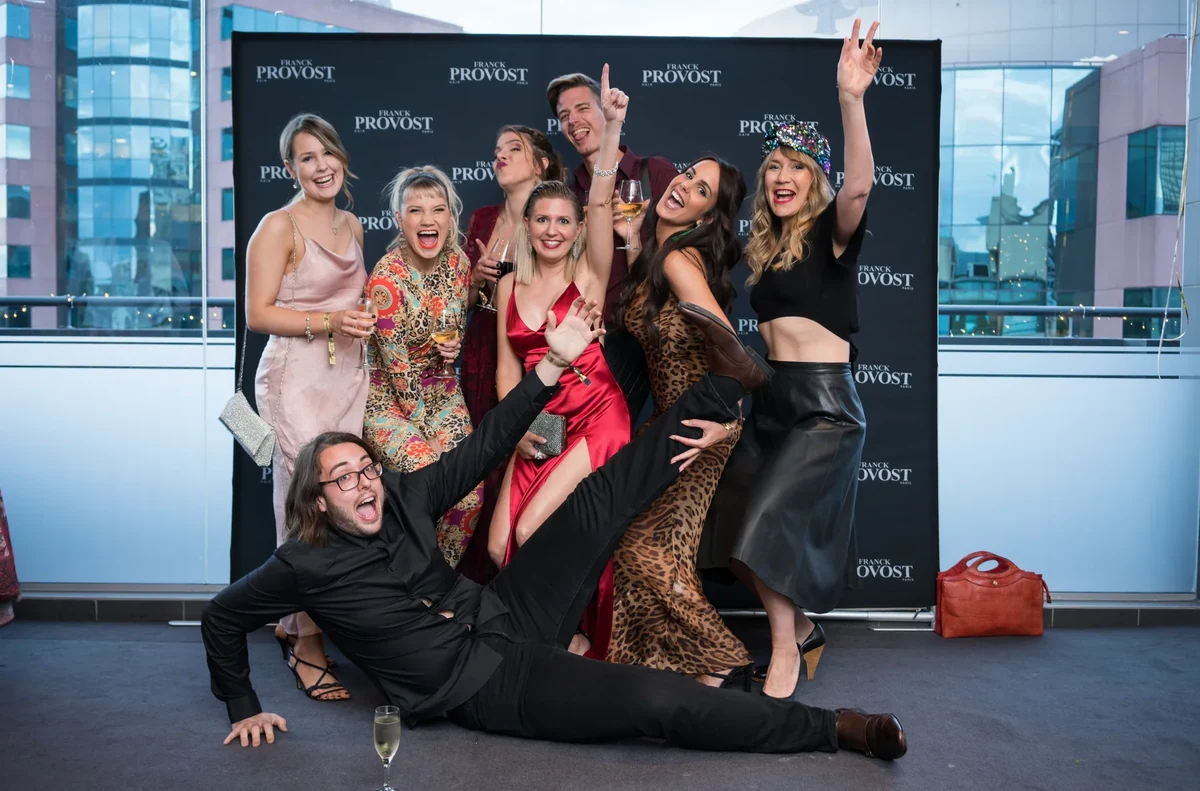 Groupe d'invités souriants et complices devant le photocall lors d'une soirée d'entreprise à Marseille